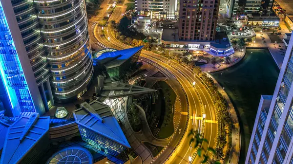 Buildings of Jumeirah Lakes Towers with traffic on the road aerial night timelapse. Top view to office buildings from skyscraper