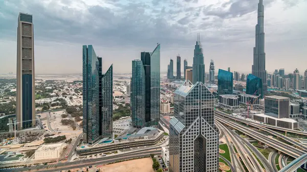 Gün batımında şehir merkezindeki gökdelenler ve Şeyh Zayed 'in yol trafiğiyle Dubai şehir merkezindeki gökyüzü çizgisi zaman çizelgesi. Kule çatısından üst hava manzarası. Gökyüzündeki bulutlar. Dubai, Birleşik Arap Emirlikleri