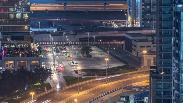 Birds eye view of Dubai skyline timelapse and rush hour traffic in downtown at night. Road with car parking between houses