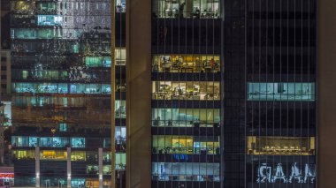 Akşam timelapse, gökdelenlerin doğal parlayan windows. Görünümü office yüksek katlı binalarda Dubai Yat Limanı ve modern konut. İnsanlar hareketli iç. Hava Üstten Görünüm.