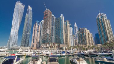 Dubai Yat Limanı defne yatların bir tekne timelapse hyperlapse. En yüksek gökdelenler kanal suya yansıyan. Mavi gökyüzü güneşli gün