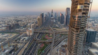 Dubai şehir merkezindeki ufuk çizgisi günden geceye geçiş zamanı. Şeyh Zayed kavşağındaki çok sayıda aydınlatma kulesiyle çatıdaki trafiğin görüntüsü.
