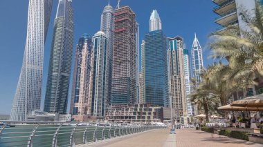 Panoramik manzaralı modern gökdelenler, geçit ve Dubai Marina timelapse yatlara, güneşli gün set görüntülemek. Birleşik Arap Emirlikleri