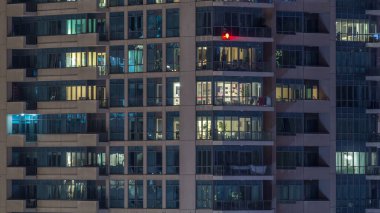 Akşam timelapse, gökdelenlerin parlayan windows. Görünümü office yüksek katlı binalarda Dubai Yat Limanı ve modern konut. İnsanlar hareketli iç. Hava üstten görünüm.
