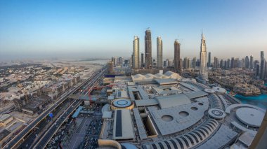 Dubai şehir merkezinden geceye geçiş zamanı modern ışıklandırılmış gökdelenler, alışveriş merkezleri ve yollardaki trafik. Gün batımından sonra yukarıdan panoramik görünüm