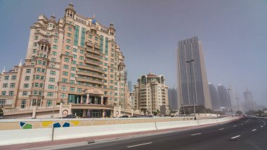 Gökdelenleri ve otelleri olan Dubai finans merkezi zaman atlaması yaşıyor. Yol trafiği ve sisli hava. Dubai şehir merkezinde güneşli bir günde