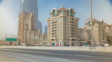 Gökdelenleri olan Dubai finans merkezi zaman atlaması yaşıyor. Yol trafiği ve sisli hava. Dubai şehir merkezinde güneşli bir günde