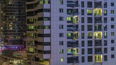 Windows çok katlı binanın içinde aydınlatma ve insanlar timelapse içinde hareketli çelik ve cam. Dubai Yat Limanı modern konut gökdelenlerin havadan görünümü.