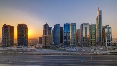 Jumeirah göl kulelerinin hava görüntüsü gün doğumunda gökdelenler Şeyh zayed yolunda ve metro hattında trafik var. Dubai marinasından çatı panoramik manzarası