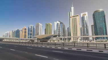 Jumeirah göl kuleleri, gökdelenler ve metro istasyonları, Şeyh zayed yolu ve tramvay hattı trafiğiyle son sürat gidiyorlar. Mavi gökyüzüyle güneşli bir gün