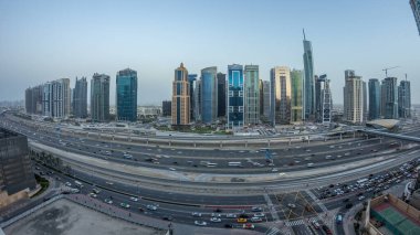 Jumeirah göl kulelerinin hava manzarası gökdelenler günden geceye geçiş zamanı Sheikh zayed yolu ve metro hattı trafiği.