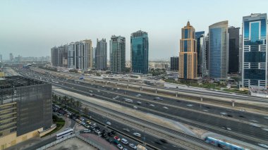 Jumeirah göl kulelerinin hava panoramik görüntüsü gökdelenler günden geceye geçiş zamanı Sheikh zayed yolu ve metro hattı trafiği.