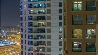 Windows çok katlı binanın içinde aydınlatma ve insanlar timelapse içinde hareketli çelik ve cam. Dubai Yat Limanı modern konut gökdelenlerin havadan görünümü.