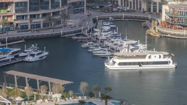 Dubai Marina 'daki gezinti güvertesi ve kanalı, lüks gökdelenleri ve yatları olan, Birleşik Arap Emirlikleri. Gün batımında limanın havadan üst görüntüsü