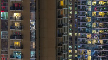 Windows çok katlı binanın içinde aydınlatma ve insanlar timelapse içinde hareketli çelik ve cam. Dubai Yat Limanı modern konut gökdelenlerin havadan görünümü