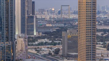 Dubai şehir merkezinden geceye geçiş zamanı, aydınlatılmış lüks modern binalar, Birleşik Arap Emirlikleri 'nin fütüristik şehir manzarası. Günbatımından sonra gökdelenden Elizabeth bölgesinin havadan görünüşü