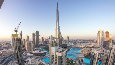 Dubai 'nin şehir merkezindeki panorama, günbegün geçişi, fıskiyeli lüks modern binalar, Birleşik Arap Emirlikleri' nin gelecekteki manzarası. Gün batımından sonra gökdelenden gökyüzü görüntüsü