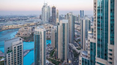 Dubai şehir merkezinden geceye geçiş zamanı, fıskiyeli lüks modern binalar, Birleşik Arap Emirlikleri 'nin geleceksel manzarası. Gün batımından sonra cam gökdelenli hava manzaralı