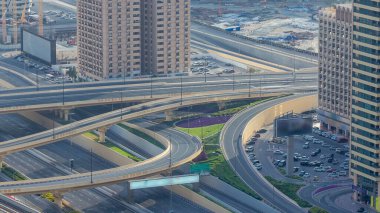 Şeyh Zayed karayolu üzerindeki yoğun bir kavşakta trafik vardı. Arenanın arka planında inşaat alanı var. Güneşli bir akşamdan önce gökdelenin çatısından bak.