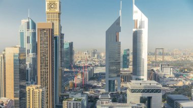 Sheikh Zayed Yolu 'nun Skyline manzarası ve Dubai, BAE' deki DIFC zaman çizelgesi. Finans merkezindeki gökdelenler ve ikiz kuleler gün batımından önce yukarıdan havadan görünüyor.