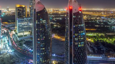 Sheikh Zayed Yolu 'nun Skyline manzarası ve Dubai, BAE' deki DIFC gece zaman çizelgesi. Aydınlatılmış gökdelenler ve finansal merkezdeki evler yukarıdan gökyüzü manzarası