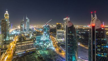 Sheikh Zayed Yolu 'nun Skyline manzarası ve Dubai, BAE' deki DIFC gece zaman çizelgesi. Işıklandırılmış gökdelenler ve mali merkezdeki inşaat sahası yukarıdan hava manzarası