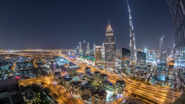 En yüksek bina ve Otoban yol trafik, Birleşik Arap Emirlikleri Dubai şehir manzarası gece timelapse. Işıklı modern kuleli gökdelenin çatı üzerinden havadan görünümü