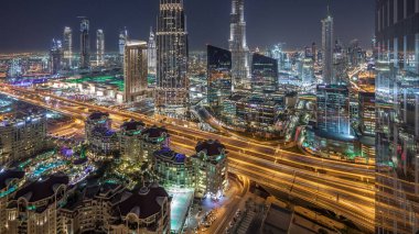 En yüksek bina ve Otoban yol trafik, Birleşik Arap Emirlikleri Dubai şehir manzarası gece timelapse. Işıklı modern kuleli gökdelenin çatı üzerinden havadan görünümü