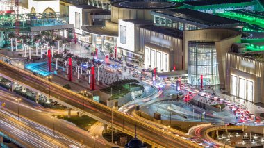 Dubai şehir gece timelapse ve karayolu trafik Alışveriş Merkezi giriş birçok taksi, Birleşik Arap Emirlikleri ile yakın. Işıklı modern binalar ile gökdelenin çatı üzerinden havadan görünümü