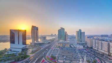 Günbatımında Dubai deresi panoramik manzarası. Tekneler, yatlar ve yollarda trafik ve araba parkı olan modern binalar. Yukarıdan hava üstü görünümü