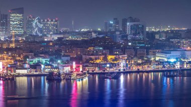 Dubai deresi gece manzarasını tekneler, yatlar ve yollarda trafik olan modern binalarla aydınlattı. Yukarıdan hava üstü görünümü