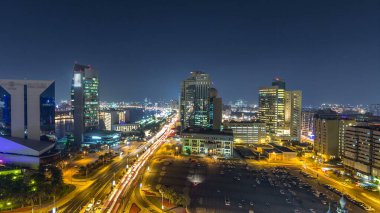 Dubai deresi gece manzarası tekneler, yatlar ve trafik ve araba park panoramalarıyla dolu modern binalar. Yukarıdan hava üstü görünümü