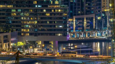 Dubai Marina havadan görünümden bir noktadan gece timelapse. Modern gökdelenler ve konut kuleleri parlayan windows ile aydınlatılmış. Köprüde trafik. Su yansımalar