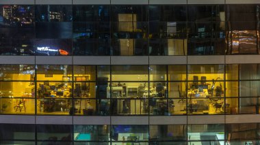Çok öykülü modern cam ve metal ofis kadar ışık gece timelapse Bina içinde parlayan pencere eşiği. İşçiler bir kutu içinde. Geceleri aydınlatılan Ofis Binası