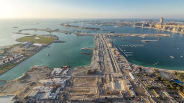 Palm Jumeirah Adası 'nın hava görüntüsü. Villaları, otelleri ve yatları olan panoramik manzaralı bir akşam. Yeni gemi terminalinin inşa süreci