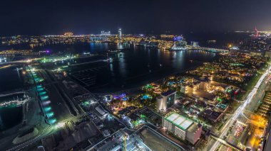 Palm Jumeirah Adası gece timelapse hava görünümünü. Üstten görünüm ışıklı Villa, otel ve yat ile. Yeni cruise terminal inşaat süreci