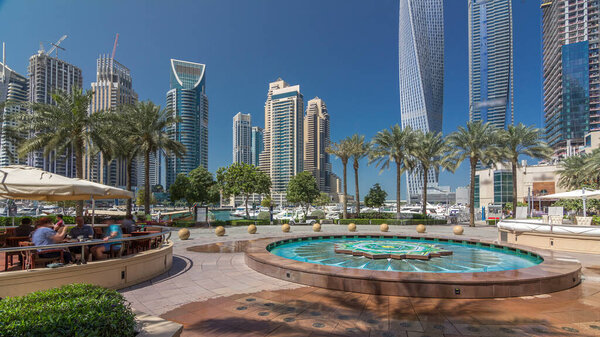 Панорамный вид на современные небоскребы, прогулочную дорожку и тупик в Дубае, вид с набережной в солнечный день. Объединенные Арабские Эмираты
