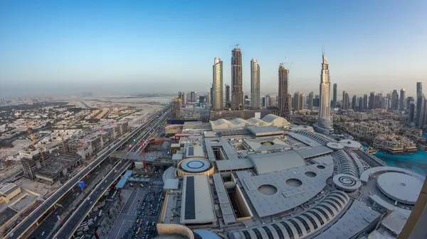 Dubai şehir merkezinden geceye geçiş zamanı modern ışıklandırılmış gökdelenler, alışveriş merkezleri ve yollardaki trafik. Gün batımından sonra yukarıdan panoramik görünüm