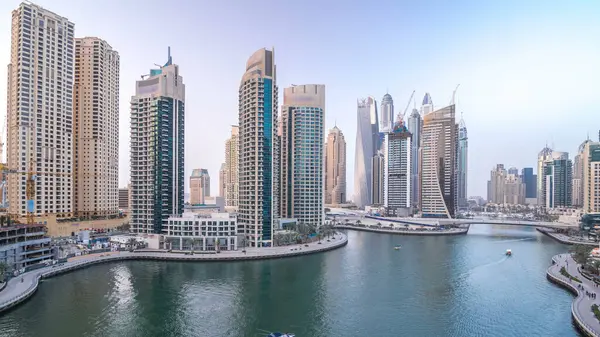 Dubai Marina gezinti güvertesi ve kanalı, gün batımından sonra Dubai, BAE 'de yüzen yat ve teknelerle hava görüntüsü. Modern kuleler ve trafik