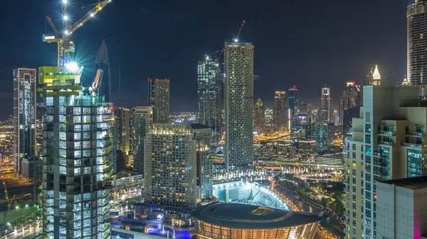 ドバイのダウンタウンの夜のタイムラプス 照明付きの豪華な近代的な建物 アラブ首長国連邦の未来的な街並み 超高層ビルからの建設現場と空中トップビュー — ストック写真