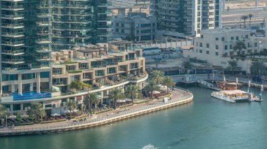 Lüks Dubai Yat Limanı kanal geçen tekneler ile ve avuç içi timelapse ile promenade, üst görüntülemek üzerinden yukarıda akşam gün batımına. Dubai, Birleşik Arap Emirlikleri