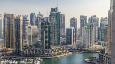 Dubai Marina 'nın güzel hava manzarası panorama ve kanalı. Dubai, BAE' de günbatımından önce yüzen yatları ve tekneleri var. Geceleri modern kuleler ve gökdelenler