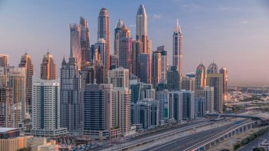 Dubai Yat Limanı gökdelenler hava üstten görünüm Jlt üzerinden sabah Dubai timelapse, BAE güneş doğarken sırasında. Modern kule uzun gölgeler aşağıya taşınması ve Şeyh zayed yolu üzerinde trafik ile.