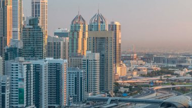 Dubai Yat Limanı gökdelenler hava üstten görünüm Jlt üzerinden sabah Dubai timelapse, BAE güneş doğarken sırasında. Modern kule uzun gölgeler aşağıya taşınması ve Şeyh zayed yolu üzerinde trafik ile.