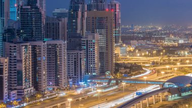 Dubai Yat Limanı gökdelenler hava üstten görünüm güneş doğmadan önce Jlt gelen Dubai gece gün timelapse, Birleşik Arap Emirlikleri için. Işıklı modern kuleleri ve Şeyh zayed yolu üzerinde trafik.