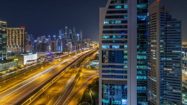 Dubai Yat Limanı timelapse fantastik çatı manzarası. Işıklandırılmış gökdelenler büyük bir şehrin gece, Birleşik Arap Emirlikleri. Havadan görünümden Jlt trafik ile Şeyh zayed yolu üzerinde