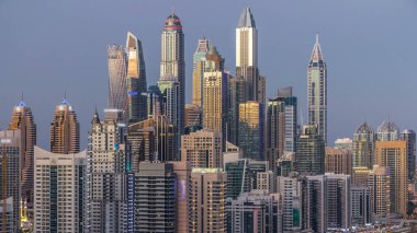 Dubai Yat Limanı kuleleri panorama gün gece geçiş timelapse için dönüş ışıkları. Gökdelenler, BAE gece aydınlatma. Hava Jlt görünümünden