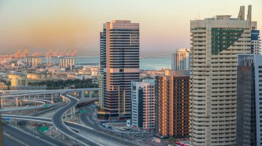 Dubai Yat Limanı gökdelenler hava üstten görünüm Jlt üzerinden sabah Dubai timelapse, BAE güneş doğarken sırasında. Modern kule uzun gölgeler aşağıya taşınması ve kavşak trafik ile.