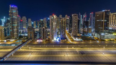 Dubai Yat Limanı timelapse tüm gece boyunca muhteşem çatı manzarası. Işıklandırılmış gökdelenler, Birleşik Arap Emirlikleri, dönüm büyük bir şehir. Hava Jlt görünümünden
