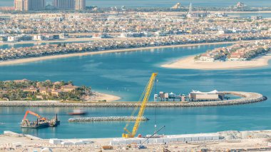 Palm Jumeirah Adası timelapse hava görünümünü. Villa, otel ve yat ile üstten görünüm akşam. Yeni cruise terminal inşaat süreci